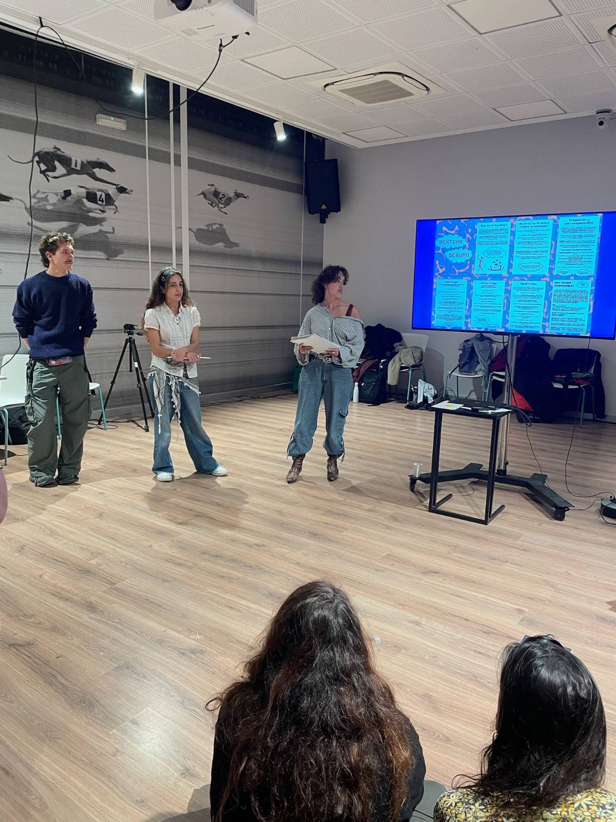 Vista general de l’espai durant l’activitat, amb assistents i pantalla de presentació.